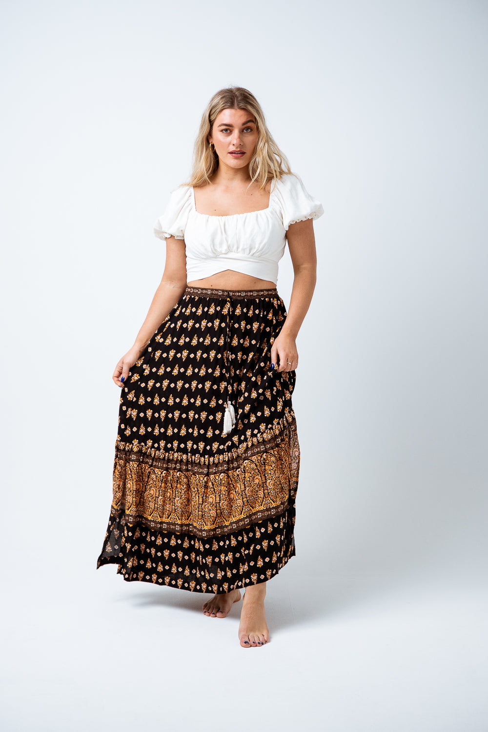 Beautiful and easy wearing, the Nina Maxi Skirt is available in a Black and Tan boho border print on super soft rayon.  Featuring an ankle length skirt with elastic waistband, tie & tassel trim and a single tiered gather hem and front split. Perfect to style with a print tee for a simple but striking day look. Available from www.arlowboutique.com