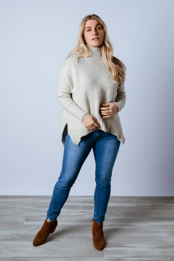 Stay cosy in the Akira Knit Jumper! Featuring a stand collar, long body length in a loose fit and a scoop hemline with side splits. An effortless cool piece, fall in love with all six colours.Available from Arlow boutique